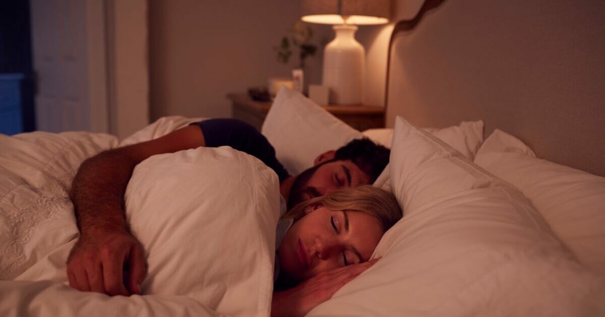 man and woman asleep in bed