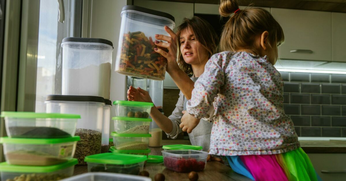 mom putting tupperware away with daughter